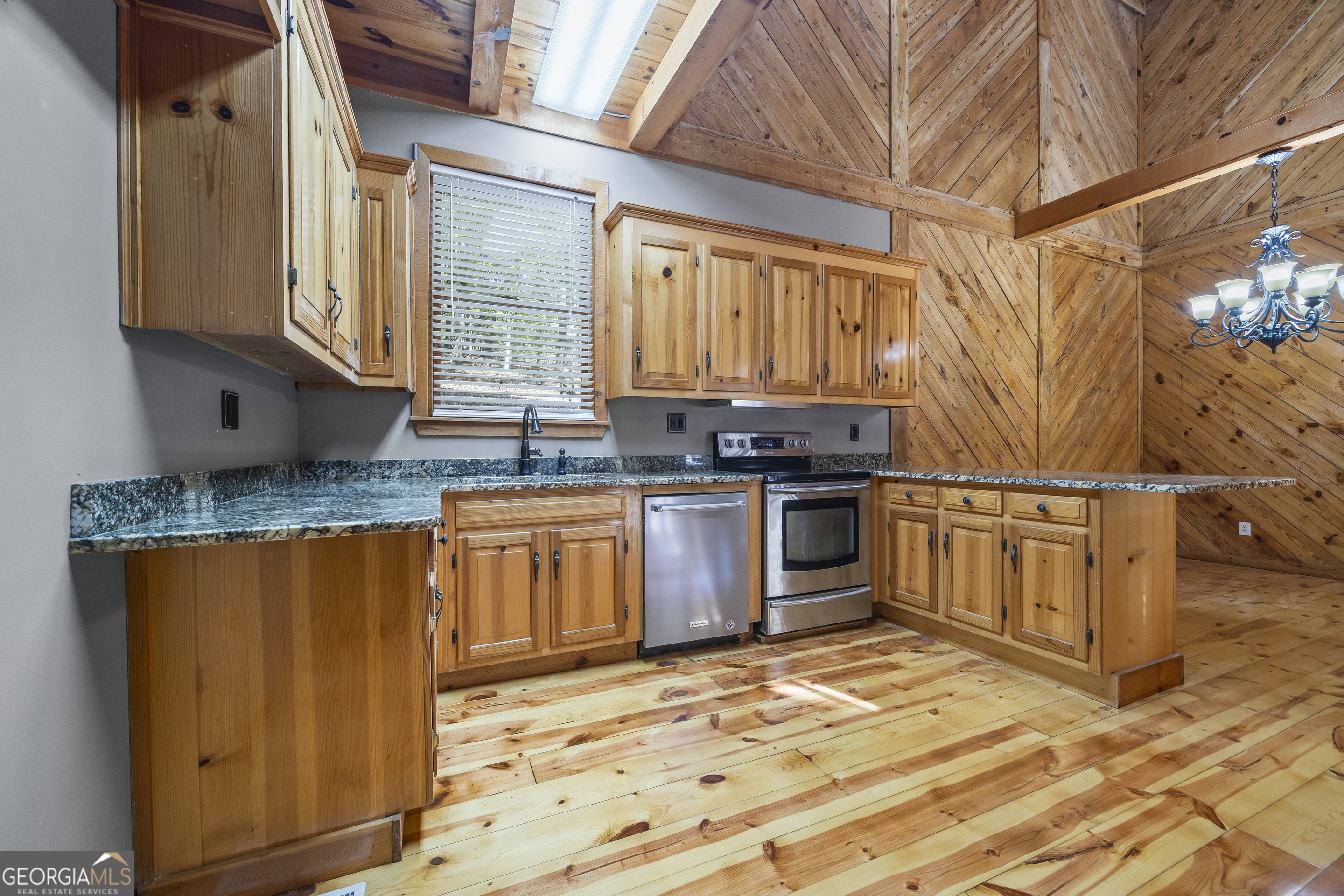 339 Ben Loudermilk Road Mount Airy, GA 30563 - Photo 19 of 49 a kitchen with granite countertop wooden cabinets stainless steel appliances and a window