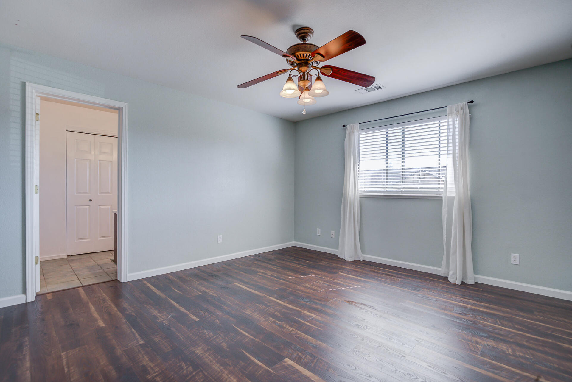 11326 Puffin Way Redding, CA 96003 - Photo 19 of 34 an empty room with wooden floor chandelier fan and windows