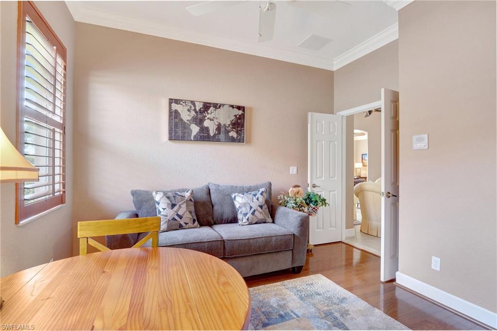 7903 Founders Circle Naples, FL 34104 - Photo 15 of 32 a bedroom with a bed and wooden floor