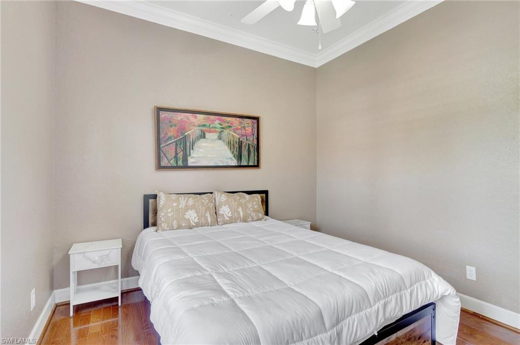 7903 Founders Circle Naples, FL 34104 - Photo 17 of 32 a bedroom with a bed and a painting on the wall