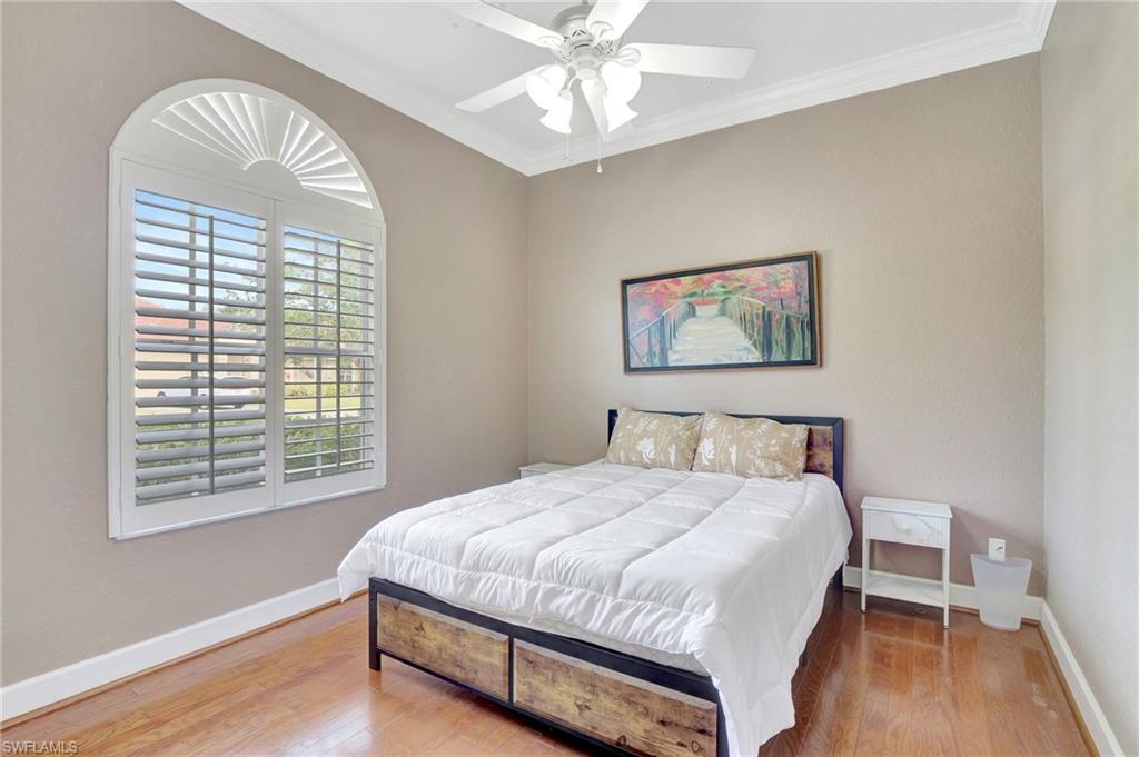 7903 Founders Circle Naples, FL 34104 - Photo 18 of 32 a bedroom with a bed and a chandelier