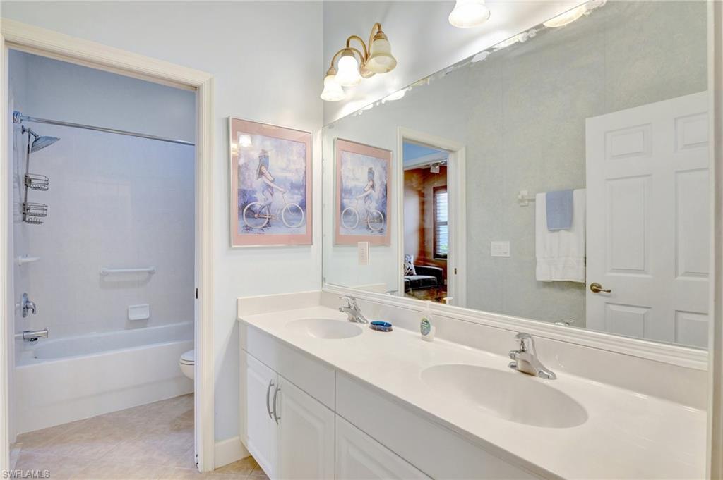 7903 Founders Circle Naples, FL 34104 - Photo 19 of 32 a bathroom with a tub a sink and mirror