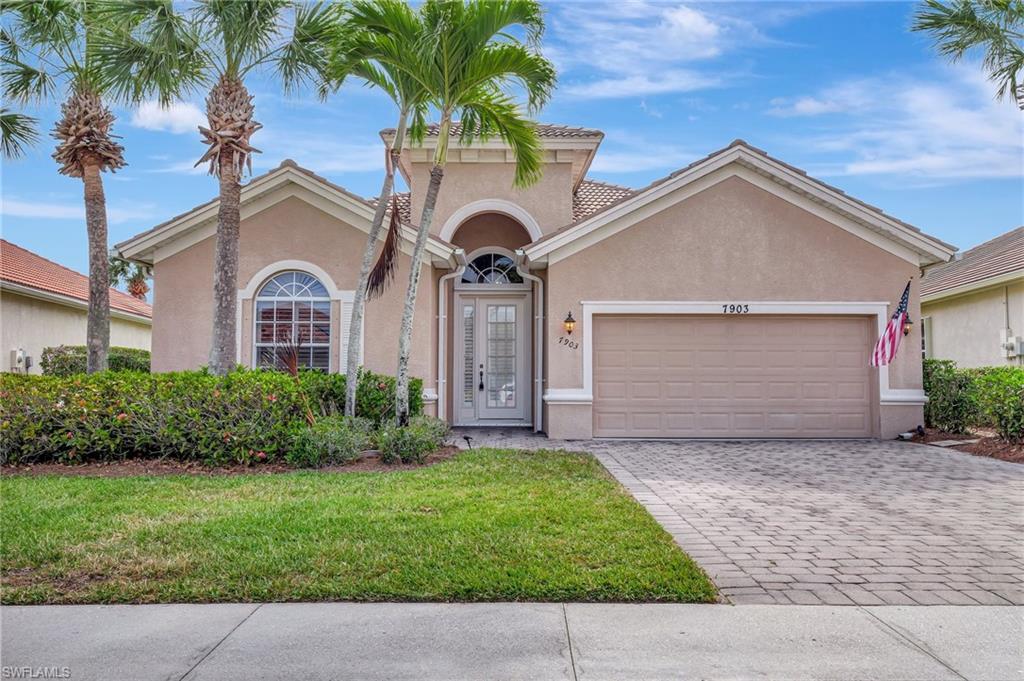 7903 Founders Circle Naples, FL 34104 - Photo 2 of 32 a front view of a house with a garden and trees