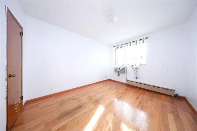 a view of a room with wooden floor and windows in it