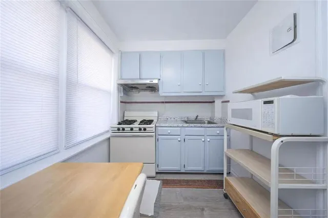 a kitchen with granite countertop cabinets and white appliances