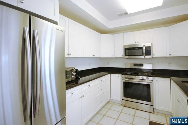 307 Jefferson Court Edgewater, NJ 07020 - Photo 13 of 36 a kitchen with stainless steel appliances granite countertop a refrigerator and a stove top oven