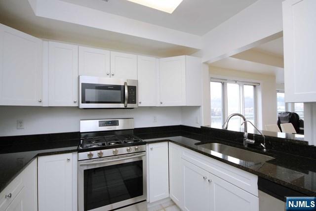 307 Jefferson Court Edgewater, NJ 07020 - Photo 14 of 36 a kitchen with granite countertop white cabinets sink and stainless steel appliances