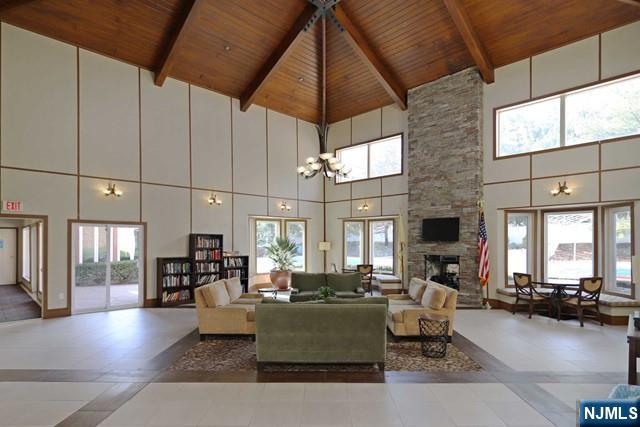 307 Jefferson Court Edgewater, NJ 07020 - Photo 27 of 36 a living room with furniture a fireplace and a flat screen tv