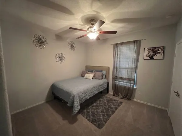 a bedroom with a bed and a ceiling fan