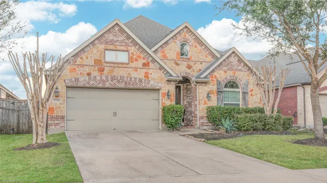 a view of a white house next to a yard with large trees