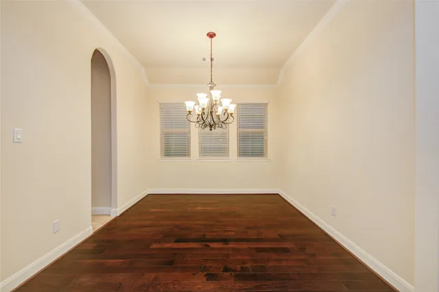 a view of wooden floor and a chandelier in a room