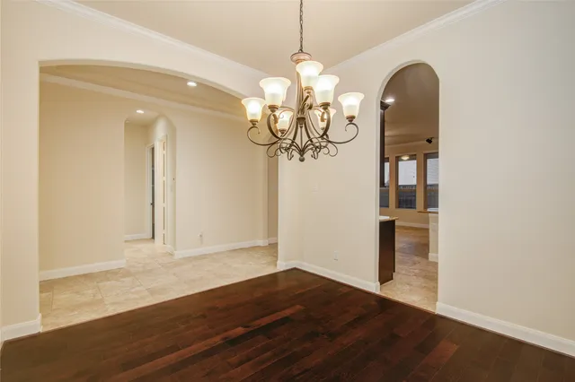 a view of a room with wooden floor and chandelier