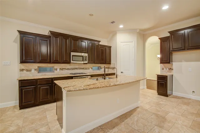 a kitchen with stainless steel appliances granite countertop a stove top oven a sink and dishwasher