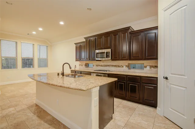 a kitchen with stainless steel appliances granite countertop a sink stove and cabinets