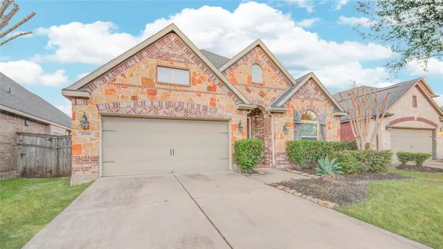 a view of a white house next to a yard and large trees