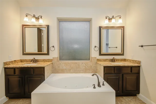 a bathroom with a tub sink and mirror