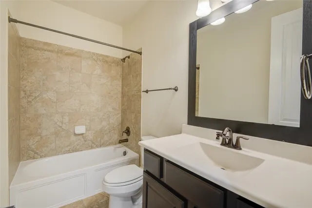a bathroom with a sink a toilet and a large mirror