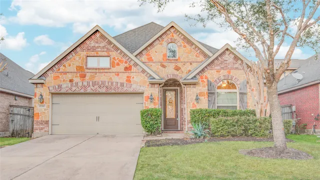 a view of a white house with a small yard and potted plants