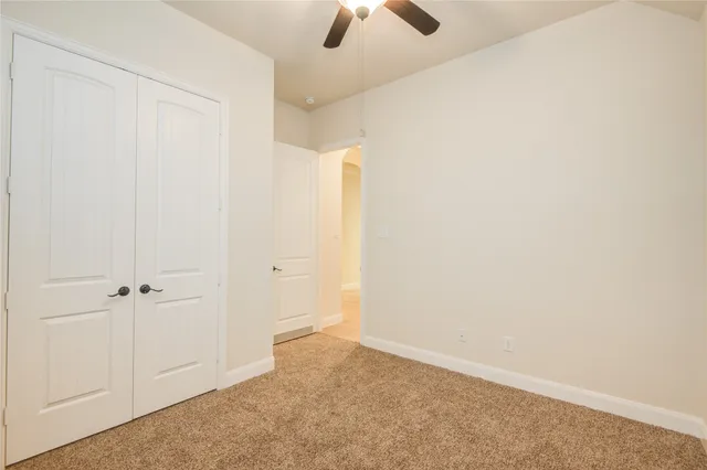 an empty room with chandelier fan