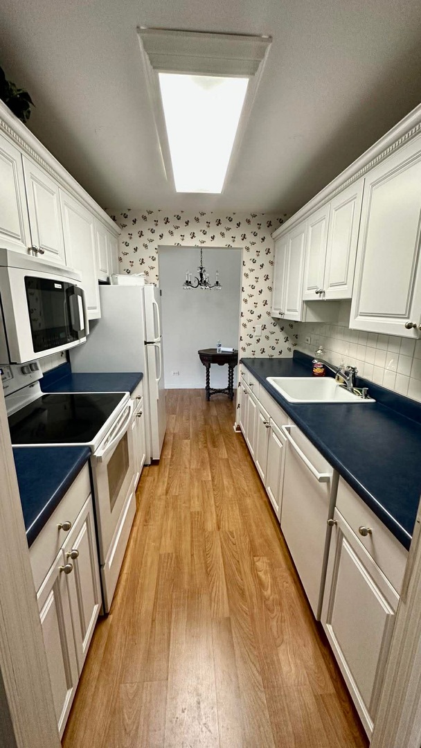 2500 Windsor Mall, Unit 2D Park Ridge, IL 60068 - Photo 6 of 13 a kitchen with stainless steel appliances a stove a sink and a microwave