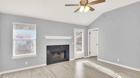 a view of an empty room with a window and fireplace