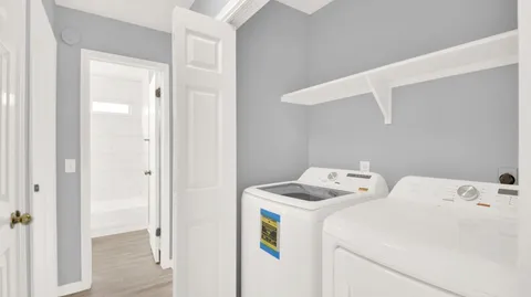 an empty room with wooden floor and ceiling fan