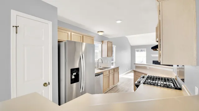 a kitchen with stainless steel appliances granite countertop a refrigerator and a sink