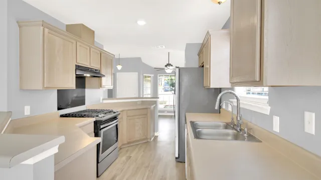 a kitchen with stainless steel appliances granite countertop a sink stove and refrigerator