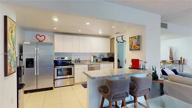 a kitchen with stainless steel appliances granite countertop a refrigerator and a stove top oven