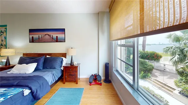 a bedroom with a large bed and a large window with outer view