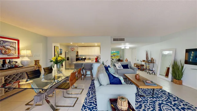 a living room with furniture kitchen view and a large window