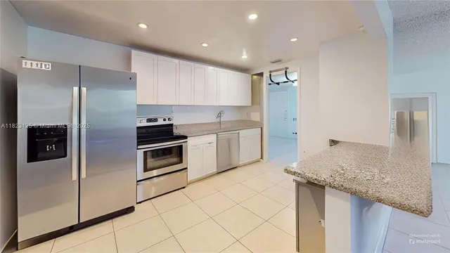 a kitchen with granite countertop a refrigerator and a sink