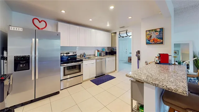 a kitchen with granite countertop stainless steel appliances and wooden cabinets