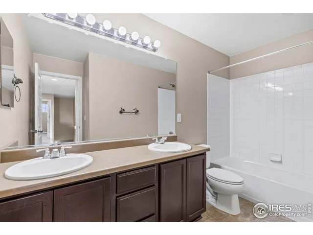 a bathroom with a granite countertop sink a toilet a mirror and shower