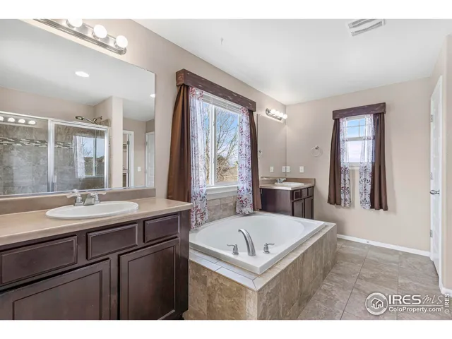 a bathroom with a sink a bathtub a mirror and vanity