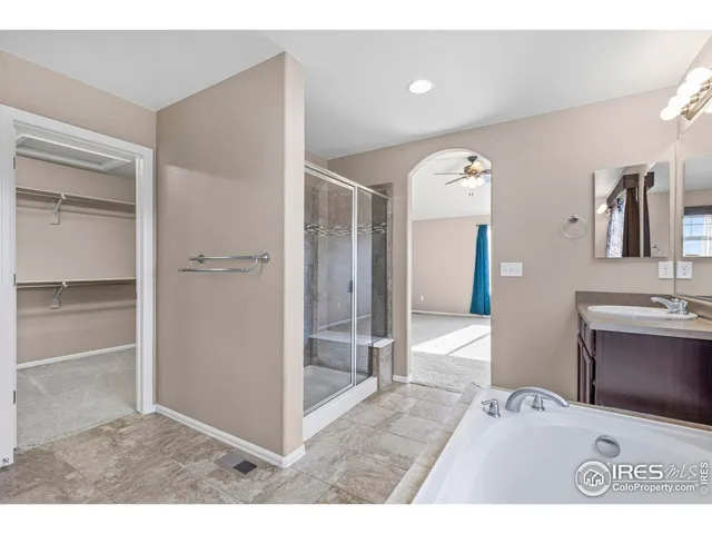 a view of a hallway with a livingroom and a bathroom with sink