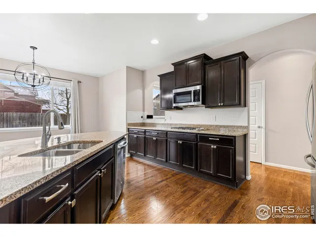 a kitchen with stainless steel appliances granite countertop a stove a sink and a microwave
