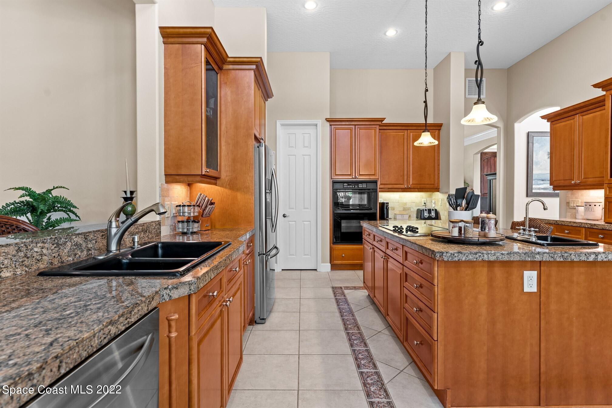 581 Nightingale Drive Indialantic, FL 32903 - Photo 18 of 67 a kitchen with granite countertop a sink and a refrigerator