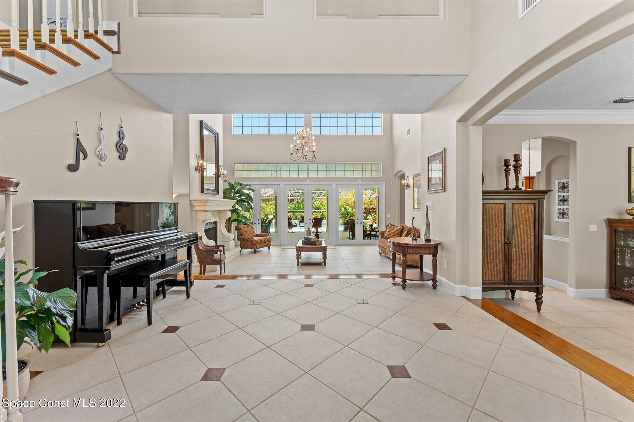 581 Nightingale Drive Indialantic, FL 32903 - Photo 10 of 67 a living room with furniture a piano and a flat screen tv