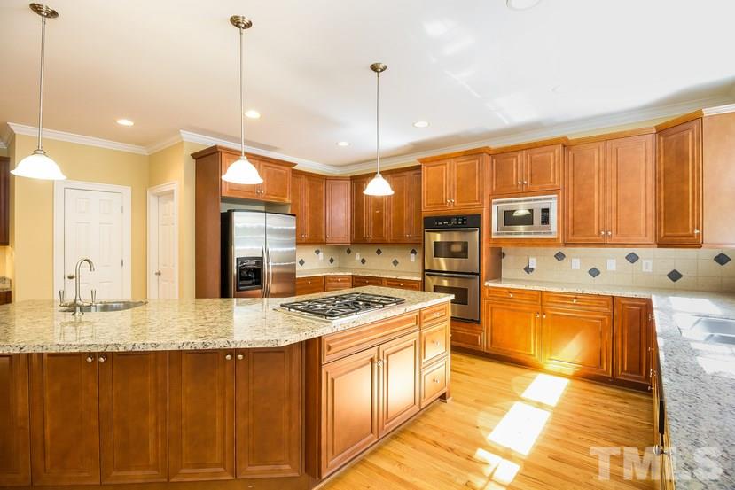 7212 Small Ridge Circle Raleigh, NC 27614 - Photo 11 of 24 a kitchen with stainless steel appliances granite countertop a stove a sink and a refrigerator