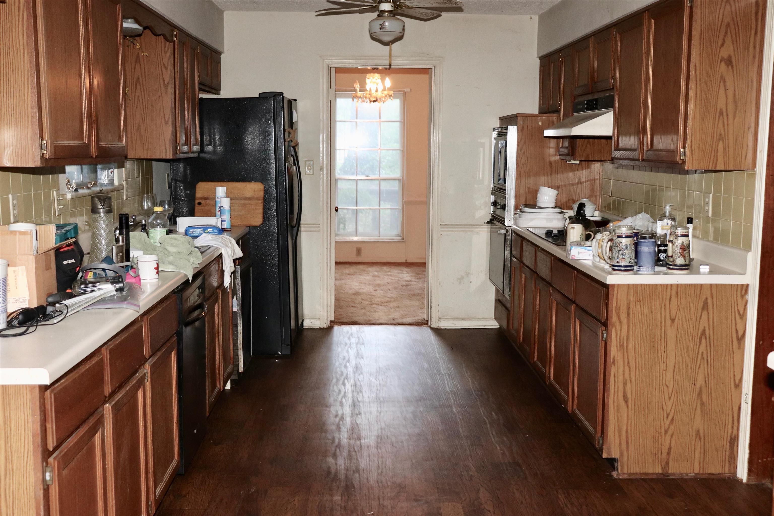 5952 Ivanhoe Road Bartlett, TN 38134 - Photo 6 of 23 a kitchen with stainless steel appliances wooden floors wooden cabinets a stove a sink and a refrigerator