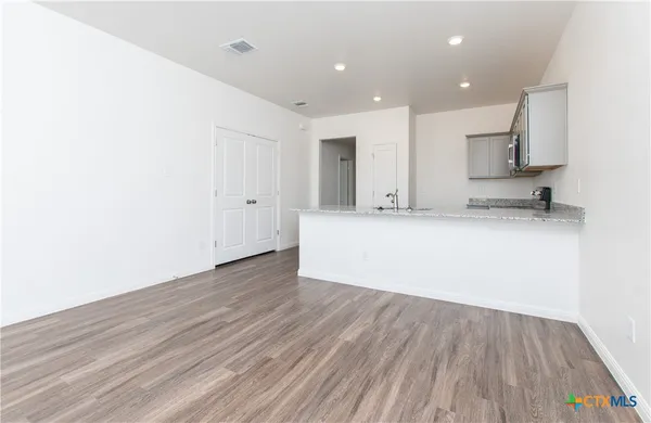 a view of a kitchen with wooden floor and a sink