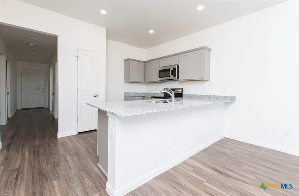 a hallway with a sink and a wooden floor