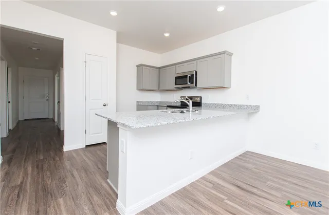 a hallway with a sink and a wooden floor