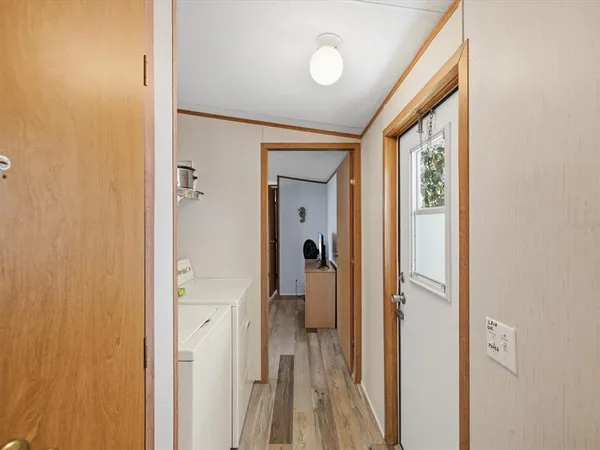 a view of a hallway with wooden floor and closet