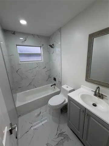a bathroom with a double vanity sink toilet mirror and bathtub
