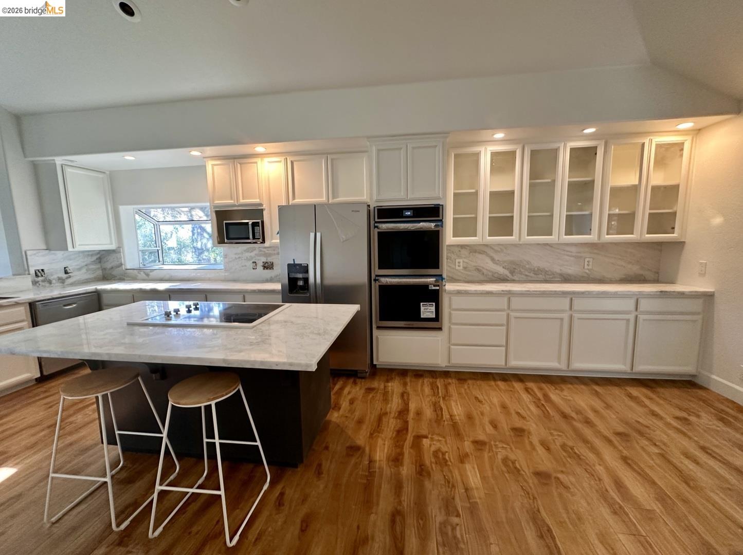 2080 Nelson Road Camino, CA 95709 - Photo 4 of 55 White cabinetry, stone countertops, integrated cooktop, stainless steel appliances, and wood-finish flooring
