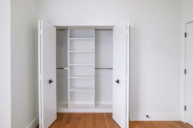 a view of walk in closet with empty racks