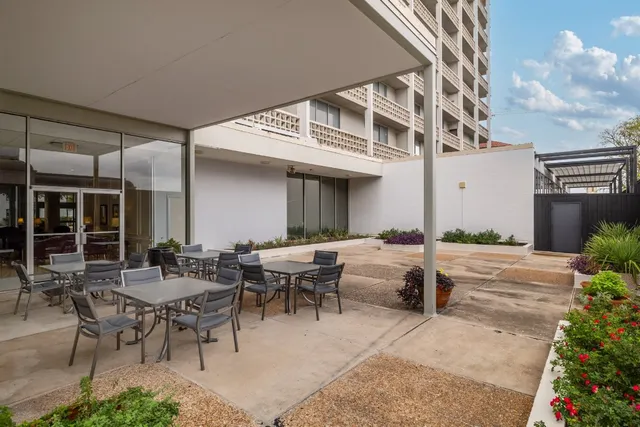 a view of a patio with couches table and chairs and potted plants