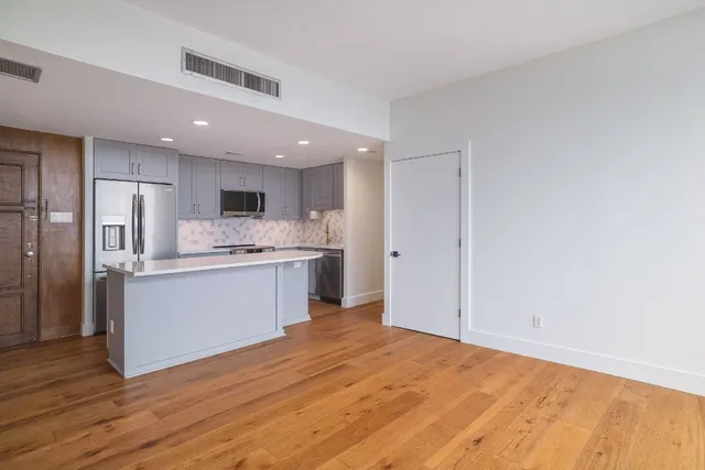a kitchen with a refrigerator sink and cabinets